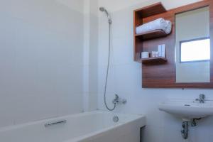 a bathroom with a bath tub and a sink at Friends Beach Hotel in Kuta Lombok +28 photos
