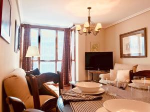 - un salon avec une table, un canapé et une télévision dans l'établissement Llanes mar y montaña, à Llanes