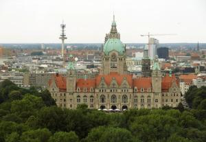 ein großes Gebäude mit einem Uhrturm darüber in der Unterkunft Deutsche Messe Zimmer - Accommodation Service Hannover Fair in Hannover