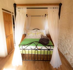 a bedroom with a bed with a canopy at Woodend Schoolhouse in Broughton in Furness