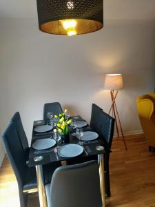 una mesa de comedor negra con sillas y una lámpara en Rosies, en Clifden