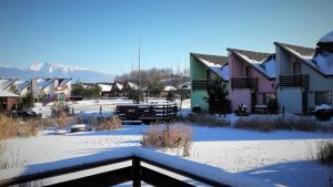 un grupo de casas con nieve en el suelo en Tatralandia Apartmán en Liptovský Mikuláš