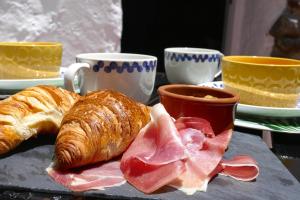 a table with croissants bread and croissants and cups of coffee at Casa Valle de Palmeras in Haría