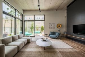 a living room with a couch and a tv and a table at The Levee in Tel Aviv