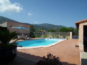 una piscina en un patio con patio en Villa climatisée piscine privée classée 4 étoiles, en Laroque-des-Albères