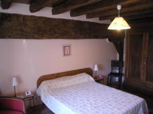 a bedroom with a bed in a room with wooden ceilings at La Ferme Du Luc in Le Chêne