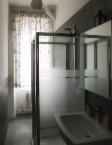 een badkamer met een glazen douche en een wastafel bij Plose Apartment in Bressanone