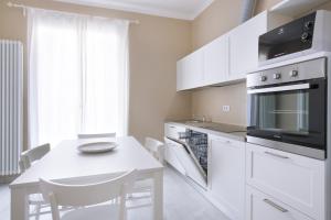 una cocina blanca con una mesa blanca y un mostrador blanco en Residenza Serenella - Dependance, en Diano Marina