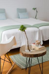 ein Schlafzimmer mit einem Bett und einem Tisch mit einer Vase auf in der Unterkunft The Minimal House in Bombarral