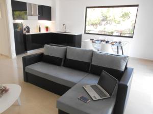 a living room with a couch with a laptop on a table at DREAM & HARMONY in Artemida