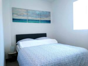 ein Schlafzimmer mit einem Bett und einem Gemälde an der Wand in der Unterkunft Apartment Seashell in Šišan