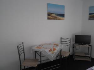 a room with a table and chairs and a television at Ferienzimmer Schwalbennest in Ostseebad Karlshagen