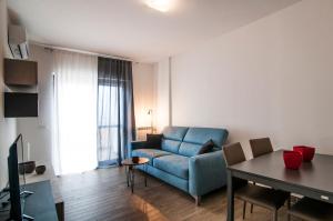 a living room with a blue couch and a table at Fonte Laurentina Apartments in Rome