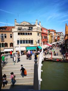 a group of people walking on a bridge over a river at Guglie Palace in Venice