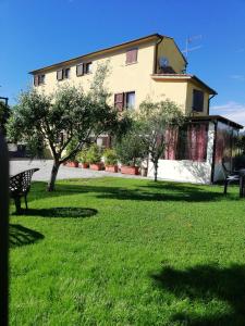 un edificio en un patio con un banco y árboles en Le Travi, en Sarzana