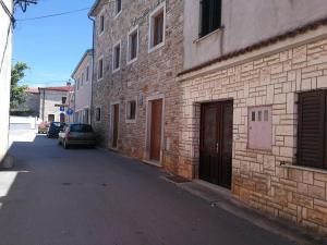 ein Backsteingebäude mit einem Auto neben einer Straße in der Unterkunft Apartment Seashell in Šišan