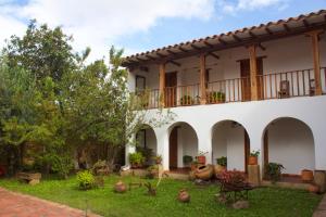 uma grande casa branca com um quintal em frente em Posada Portal de la Villa em Villa de Leyva