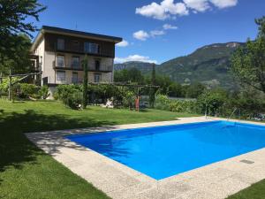 une villa avec une piscine en face d'une maison dans l'établissement Pension Gruenwald, à Andrian