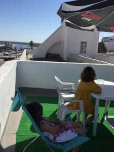 two little girls sitting in chairs at a table at Casa Tradicional Algarvia - Rooms in Faro