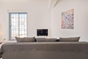エリセイラにあるBmyGuest - Ericeira Terrace Apartmentのテレビ付きの客室で、大きなソファが備わります。