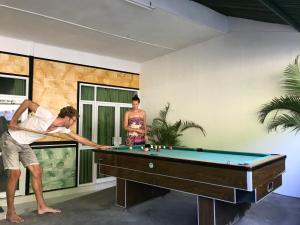 ein Mann und eine Frau spielen eine Partie Billard in der Unterkunft The Cheap & Cozy Canggu in Canggu
