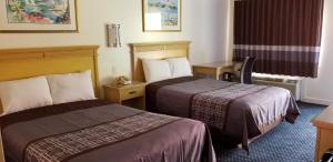 ein Hotelzimmer mit 2 Betten und einem Schreibtisch in der Unterkunft Budget Lodge in Newport News