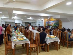 Eine Gruppe von Menschen, die an Tischen sitzen und Essen essen. in der Unterkunft Công Anh Hotel in Sầm Sơn