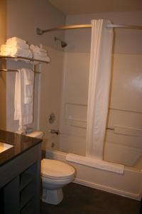 a bathroom with a toilet and a tub and a shower at Heritage Inn Express in Marysville