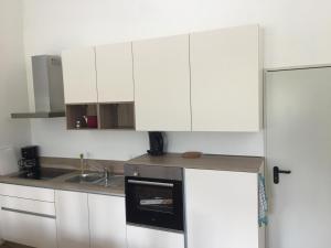 a kitchen with white cabinets and a sink at Ferienwohnung Reh in Bad Rappenau +6 photos