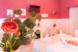 un vaso con una rosa rossa in una stanza di "Napoli in Spa" a Napoli