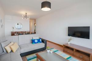 a living room with a couch and a tv at Garajau III by An Island Apart in Caniço