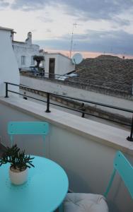 a table and chair on a balcony with a view of a roof at B&B Santa Chiara in Altamura