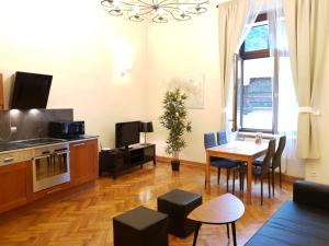 a living room with a table and a kitchen at Aparthotel Old City in Krakow