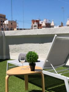 een stoel en een tafel met een wijnglas en een plant bij ÁTICO PTA 13 EN EL CENTRO DE VALENCIA VT-45727-T in Valencia