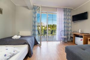 a bedroom with a bed and a view of a patio at D.W. KRYSTYNA in Dębki