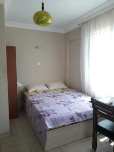 een slaapkamer met een bed met een paarse deken bij YALÇINKAYA PANSİYON in Burhaniye