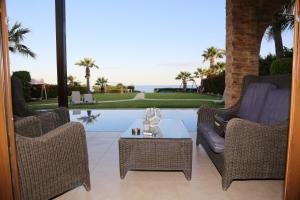 a patio with two chairs and a table and a pool at Ionion Beachfront Villa in Ayia Napa