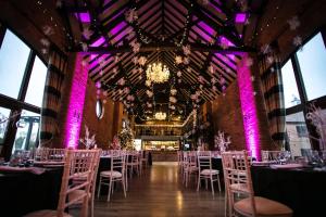 a banquet hall with tables and chairs and a chandelier at The Stratford Park Hotel & Golf Club in Stratford-upon-Avon