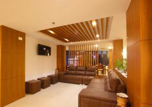 ein Wohnzimmer mit einem Sofa und einem TV in der Unterkunft Laimar Suites in Kochi
