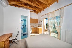 una camera da letto con un letto, una scrivania e una cucina di Villa Thea a Vrouchas Altre 27 foto