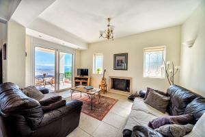 un soggiorno con mobili in pelle e un camino di Villa Thea a Vrouchas