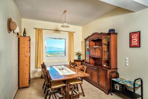 a dining room with a table and chairs and a window at Villa Thea in Vrouchas