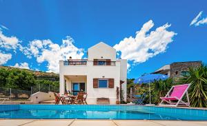 a villa with a swimming pool and a house at Villa Thea in Vrouhas