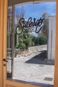 Suberito rooms&bar في تيرليتسي: باب زجاجي به لافته لمتجر