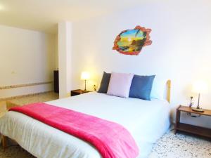 een slaapkamer met een wit bed met een roze deken erop bij Carta Apartment in San Andrés in San Andrés