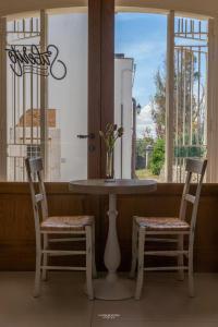 een tafel en 2 stoelen in een kamer met een raam bij Suberito rooms&bar in Terlizzi