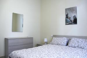 a bedroom with a bed with a dresser and a mirror at Along the Canal smart flat Naviglio - 4 people in Corsico