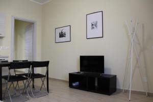 sala de estar con TV, mesa y sillas en Along the Canal smart flat Naviglio - 4 people en Corsico
