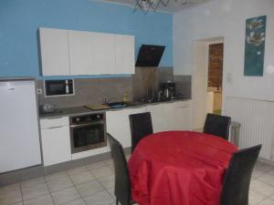 a kitchen with a table with a red table cloth at maison du haut pont in Saint-Omer +6 photos