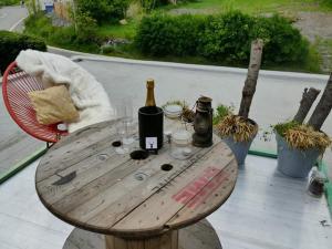 ein Holztisch mit einer Flasche Wein und Gläsern in der Unterkunft Oh deer! in Vaux-sur-Sûre